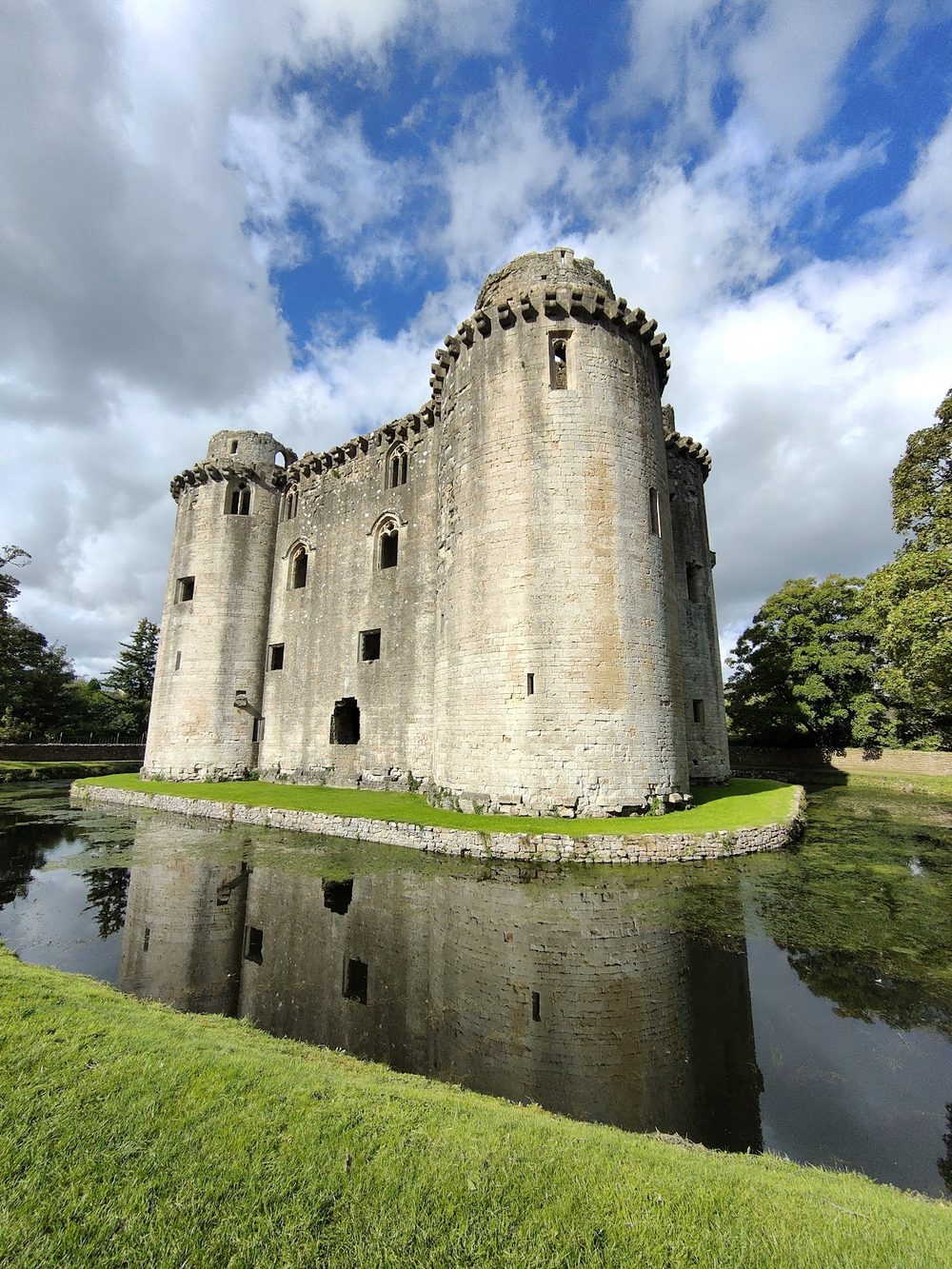 Nunney Castle, Somerset - licensed in a single line in 1373, and moated in a valley bottom overlooked by higher ground.